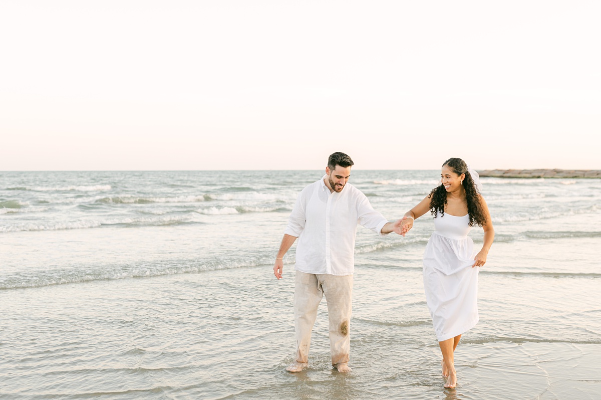 Couple running on the beach by Houston wedding photographer Eric & Jenn Photography