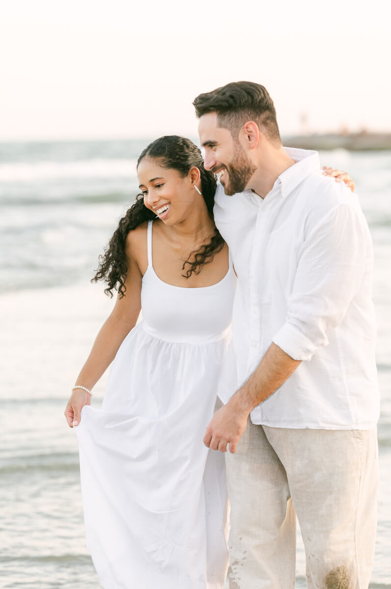 couple running through the water on Galveston beach