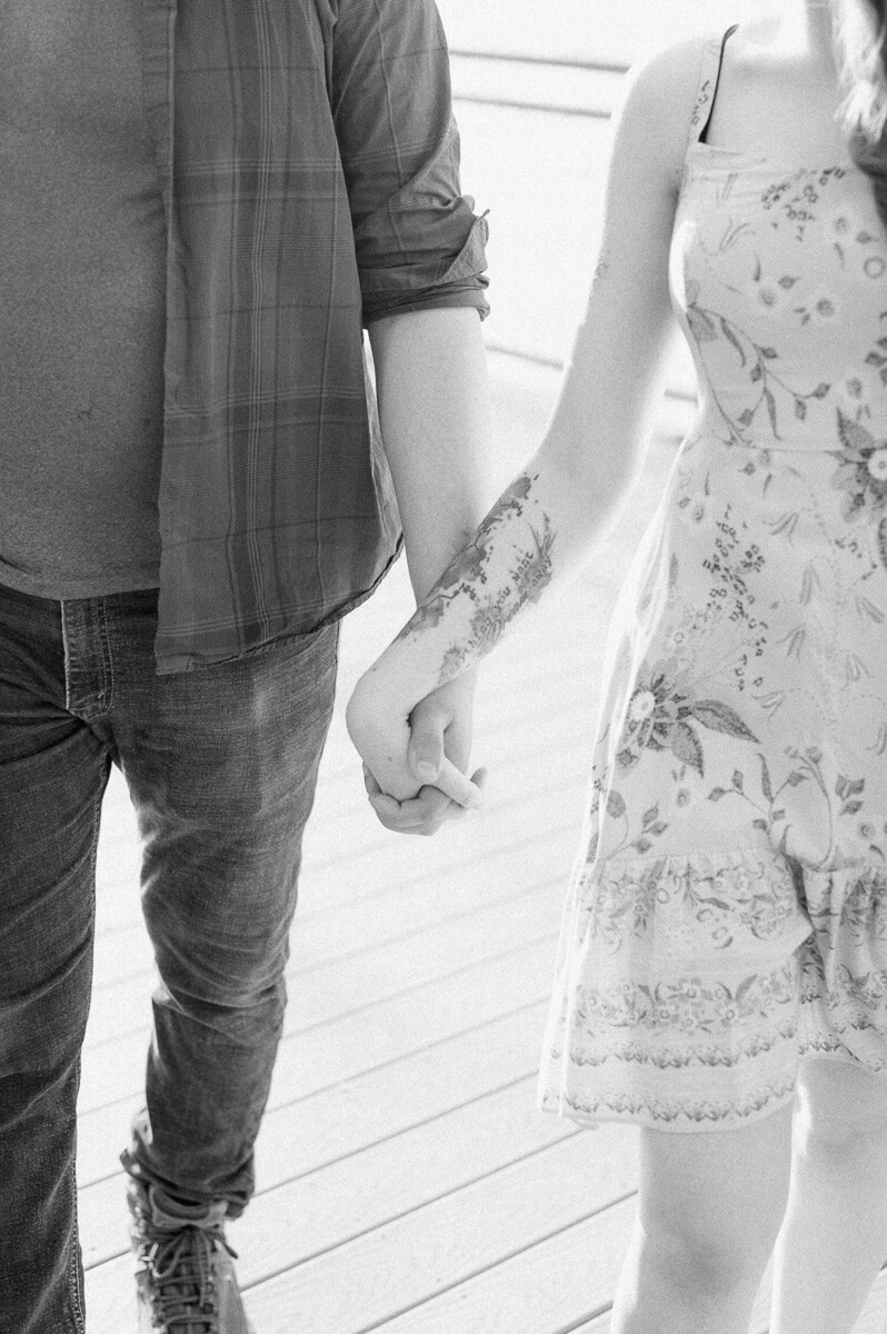 black and white photo of a couple holding hands 