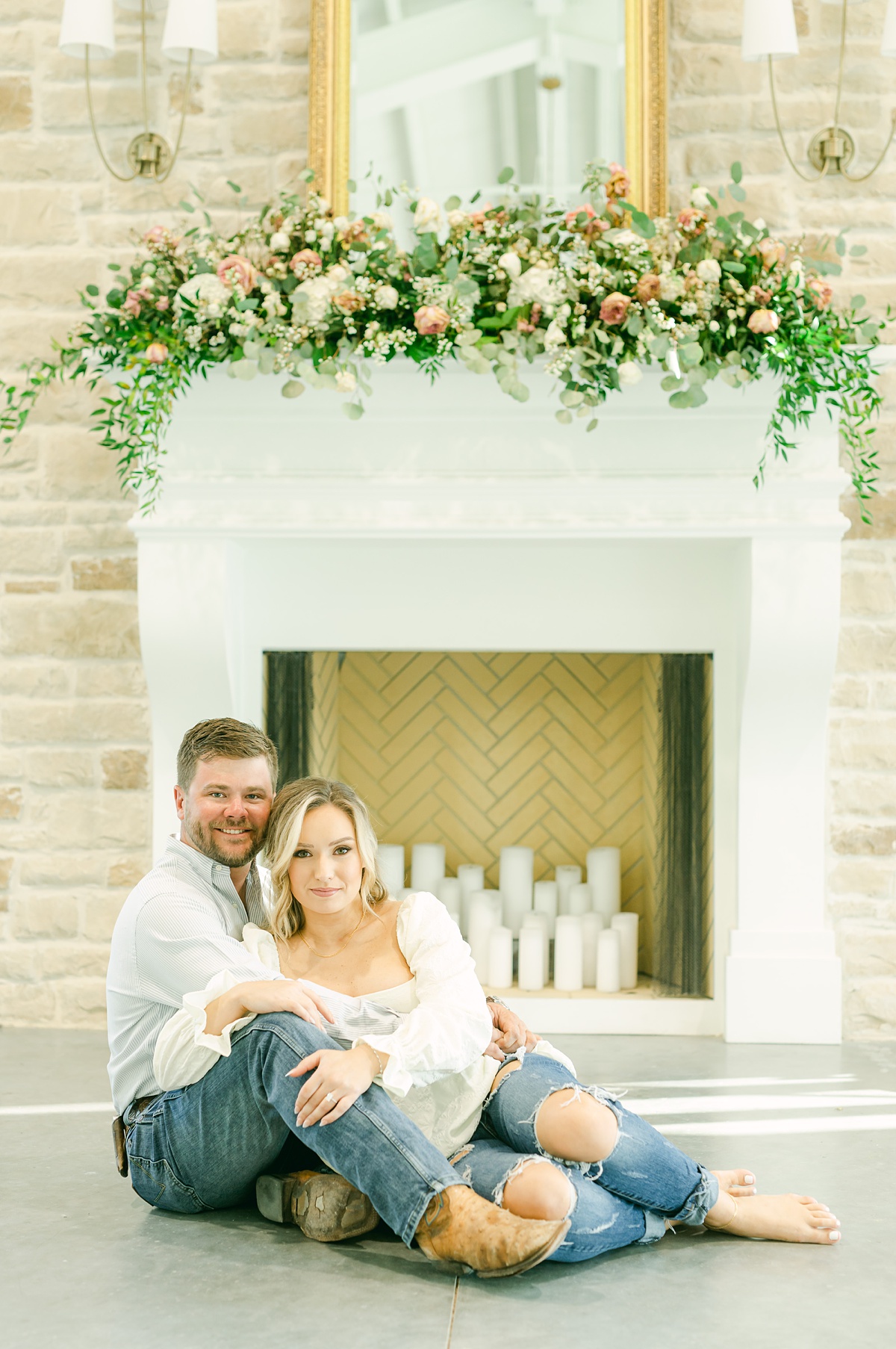 a couple sitting in front of the fireplace at magnolia grove wedding venue