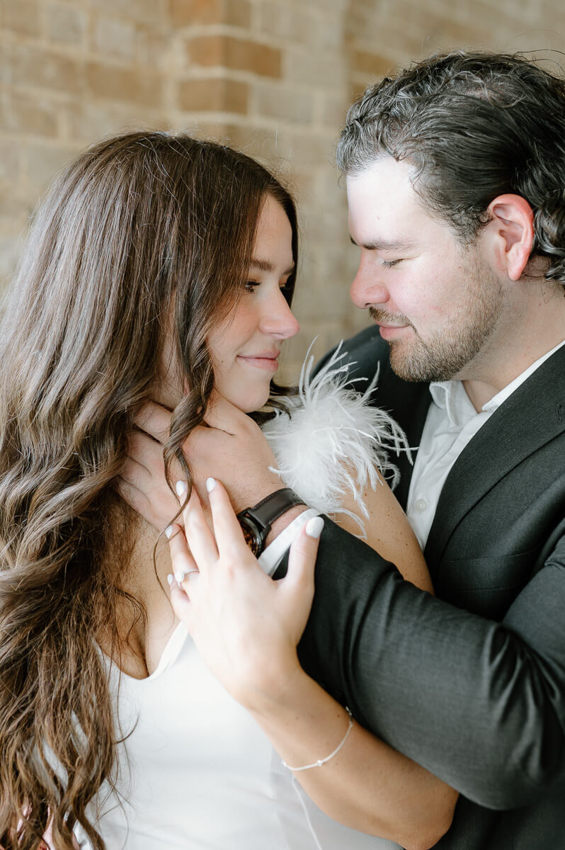 a couple walking in front of a brick wall 