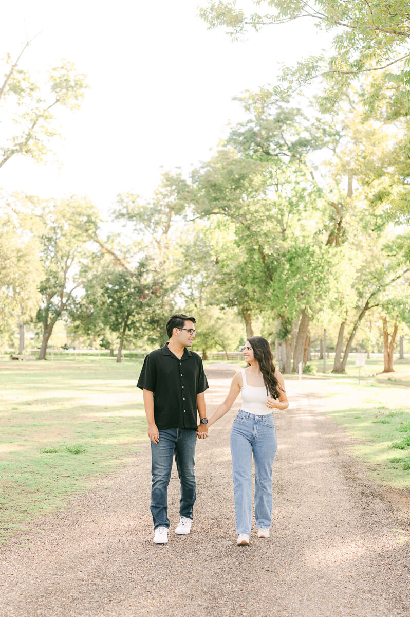 a couple walking and holding hands at their Houston engagement session