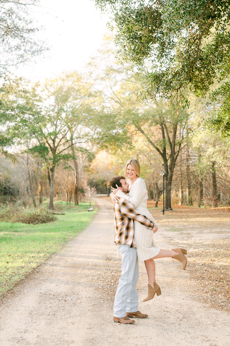 groom picking up bride at their engagement session in houston