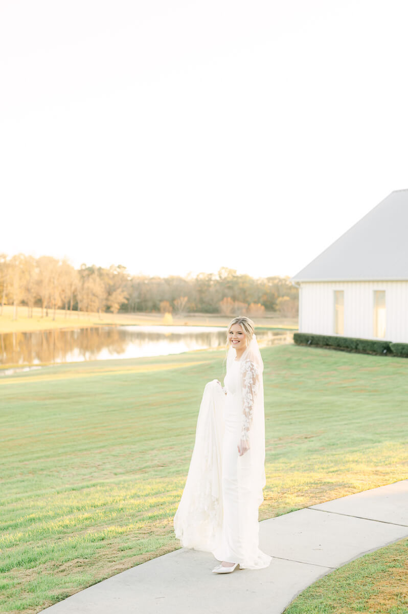 a bride walking on the sidewalk leading from the farmhouse chapel