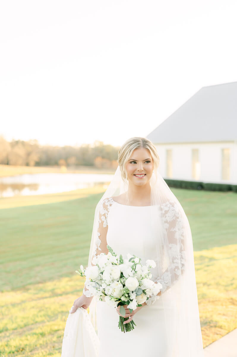 a bride walking on the sidewalk leading from the farmhouse chapel