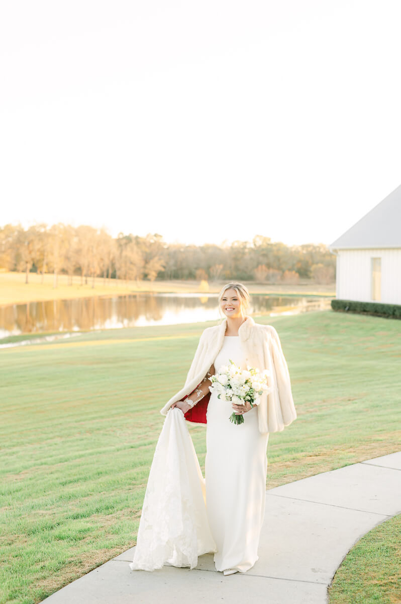 a bride at the farmhouse wedding venue wearing her grandma's fur coat 