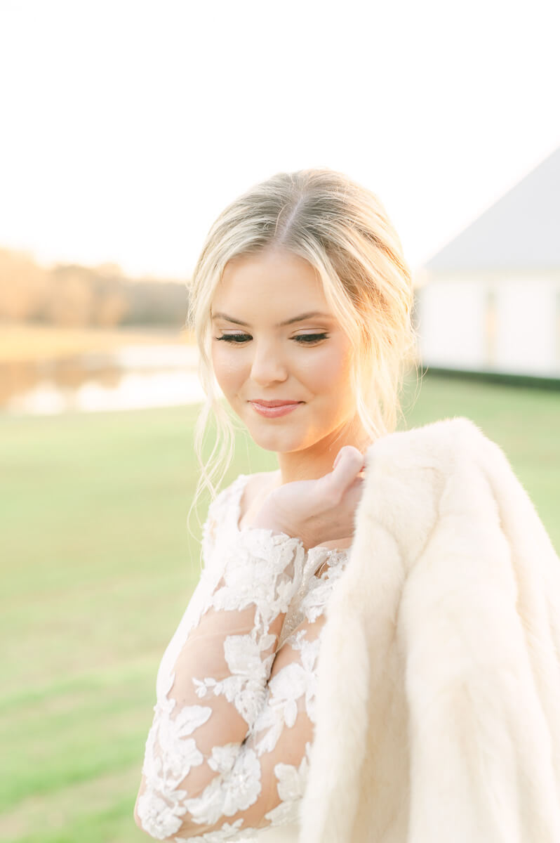 a bride at the farmhouse wedding venue wearing a fur coat 