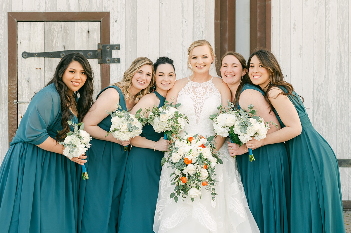 bridesmaids hugging in front of beckendorff farms