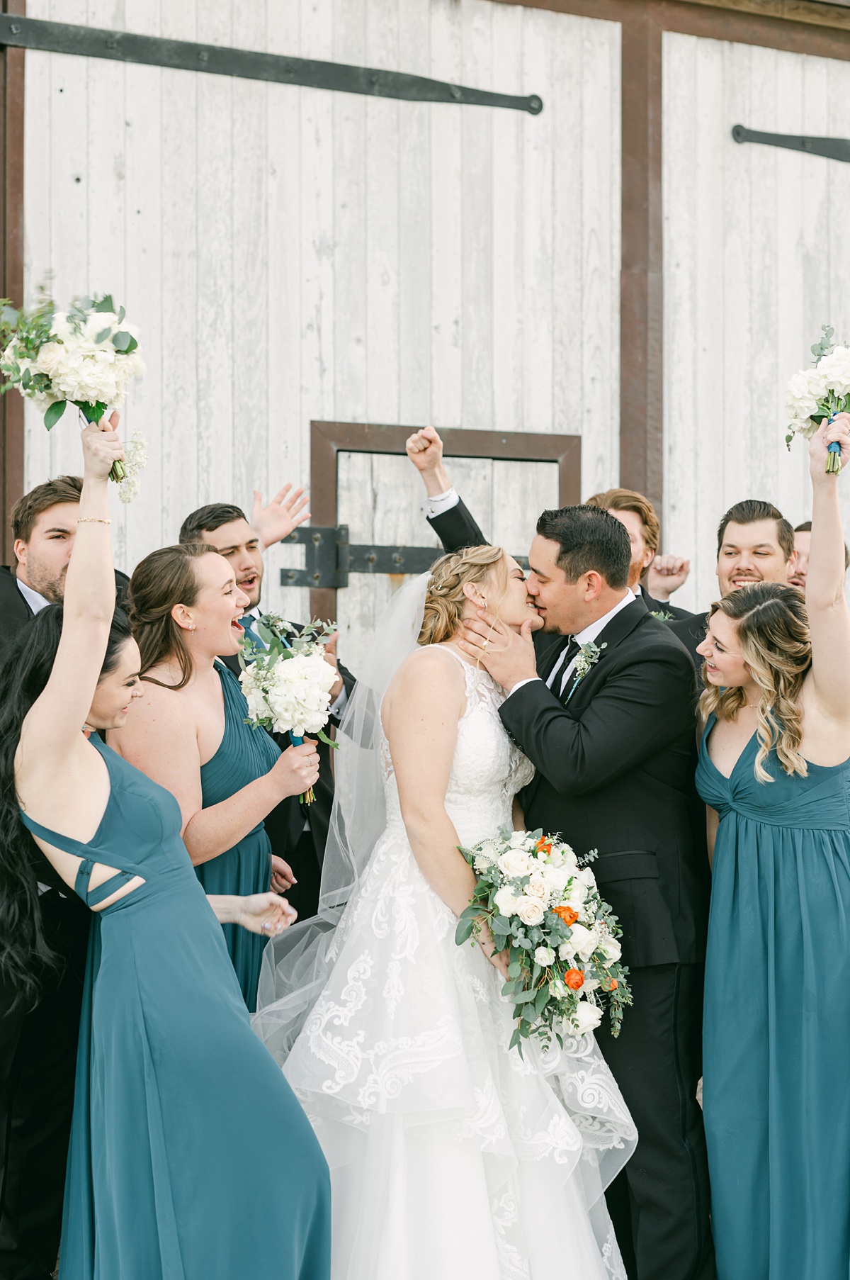 wedding party cheering for couple as they kiss