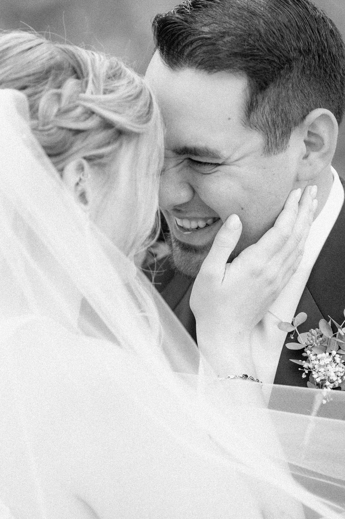 groom smiling at his bride in black and white