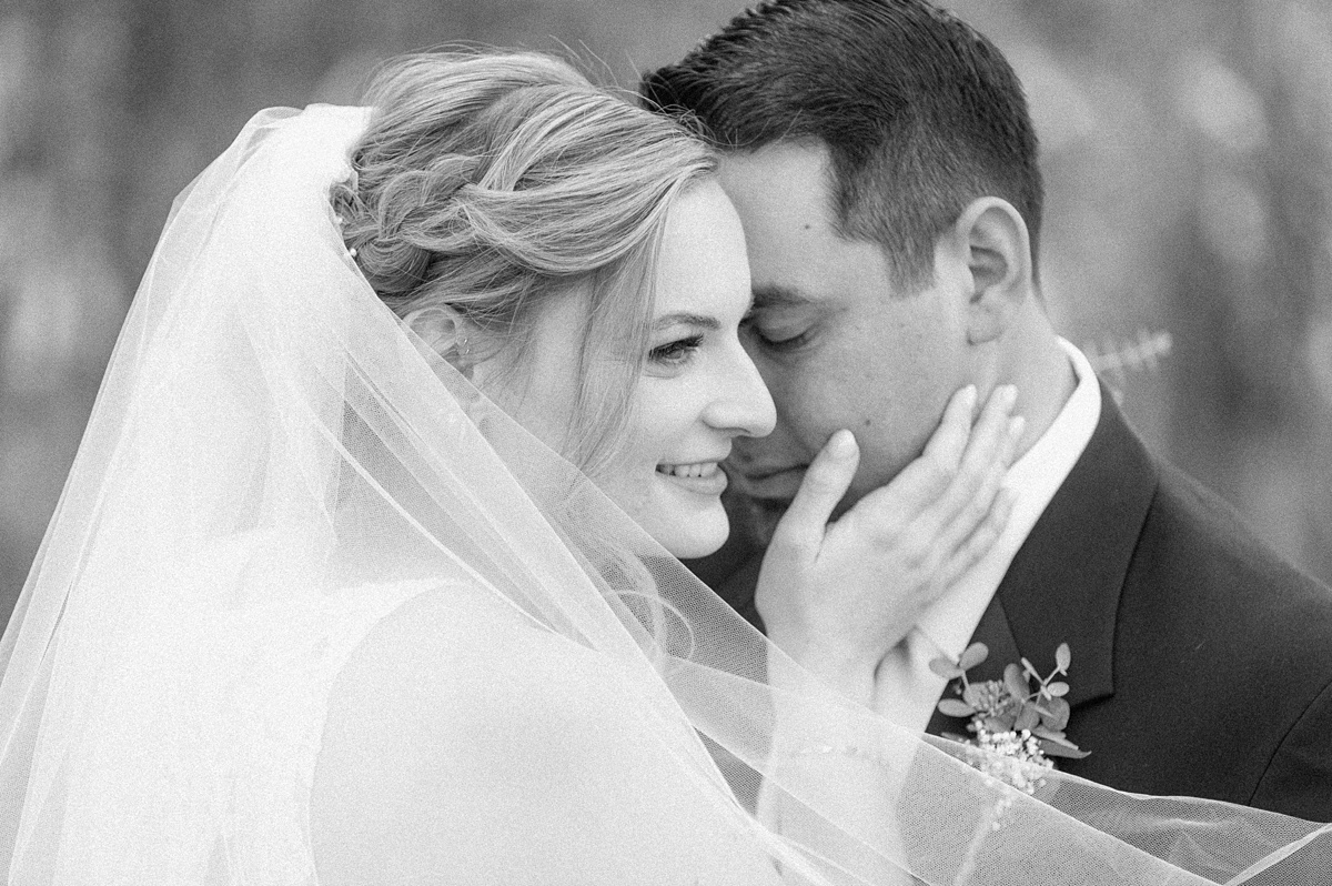 black and white romantic photo of couple with veil