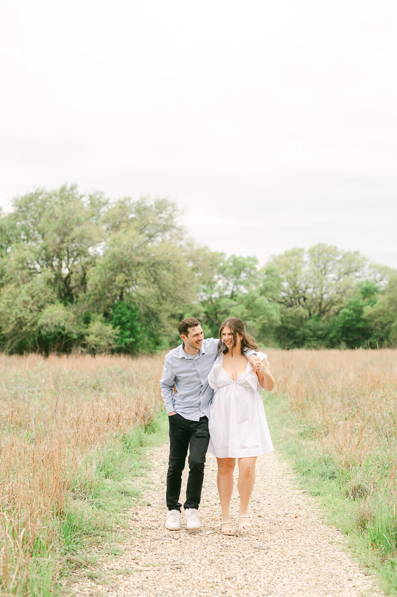 couple walking and laughing at their houston engagement photography session