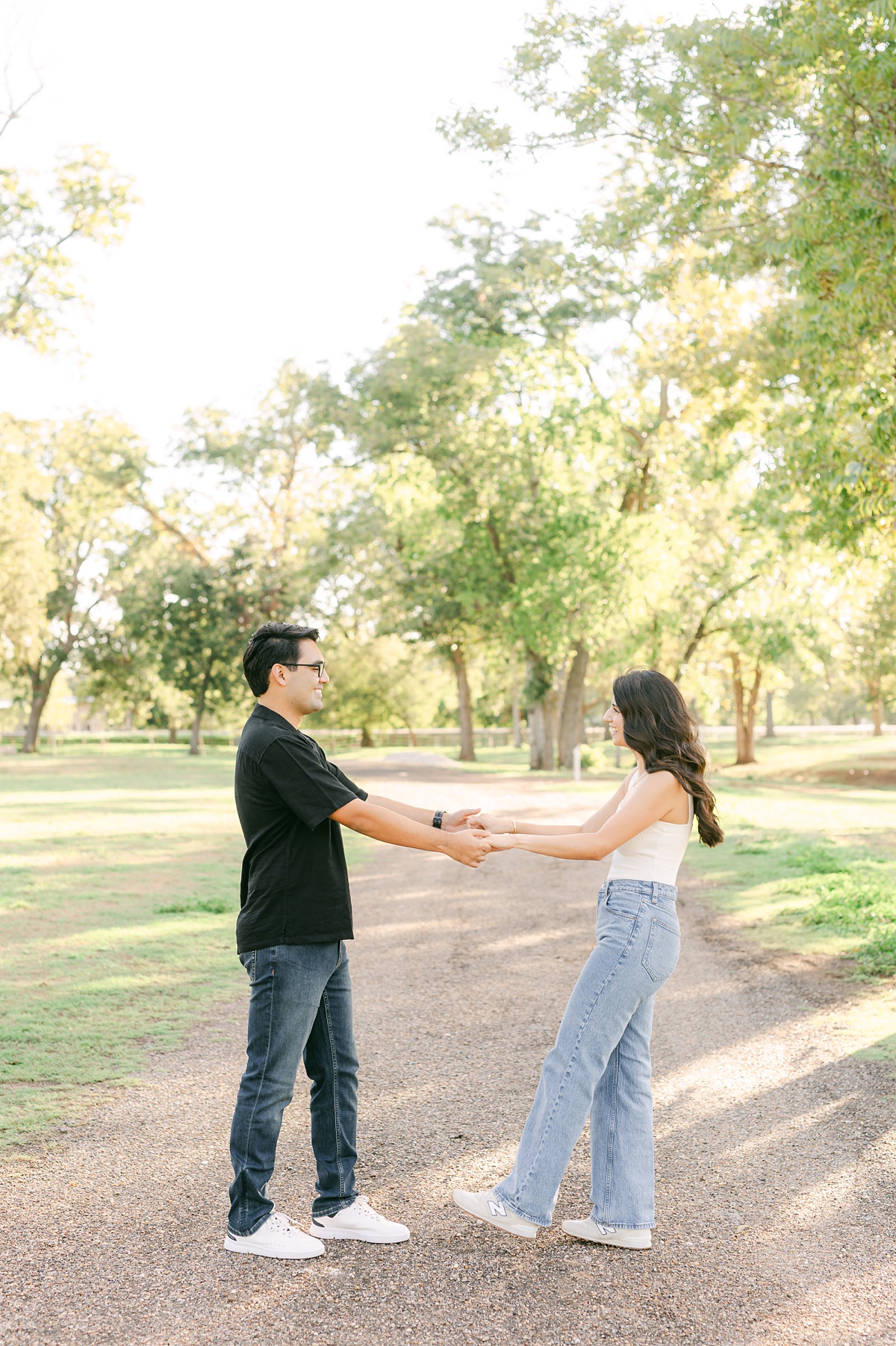 couple holding hands and spinning during their Houston engagement session 