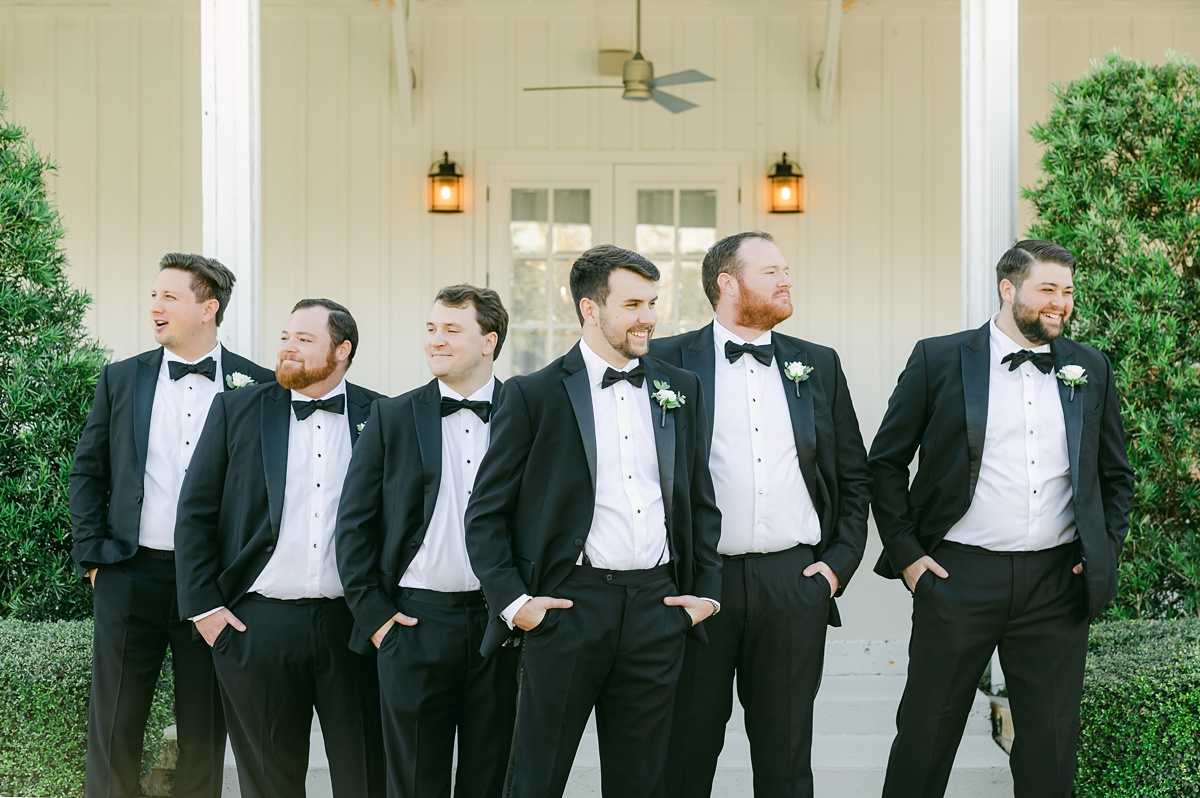 groomsmen laughing during wedding party photos at the farmhouse