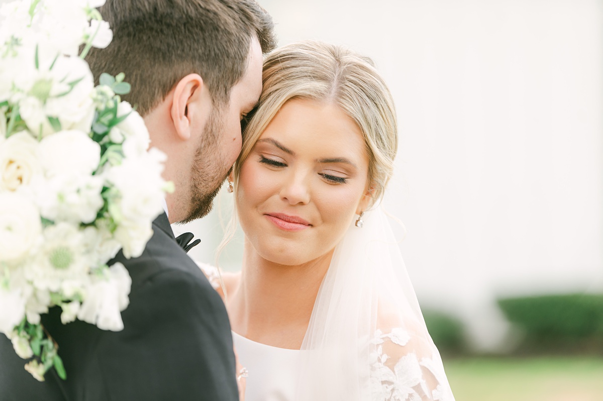 close up photo of a bride snuggling her groom