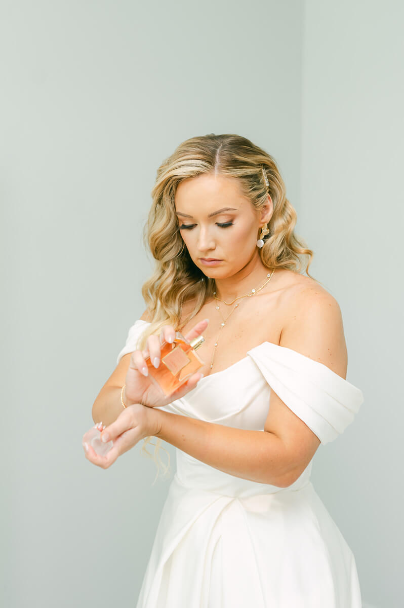 bride putting on perfume at Magnolia Grove wedding venue 