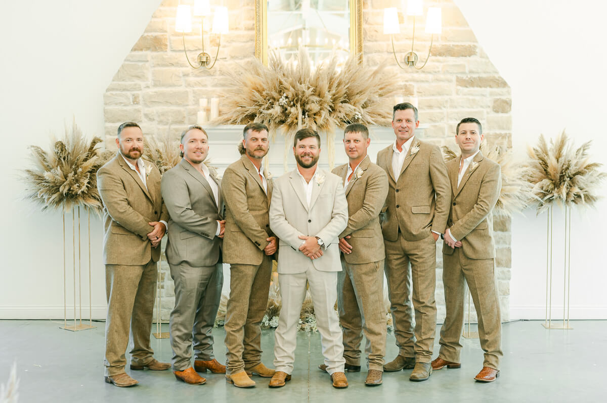 groomsmen wearing khaki in front of fireplace