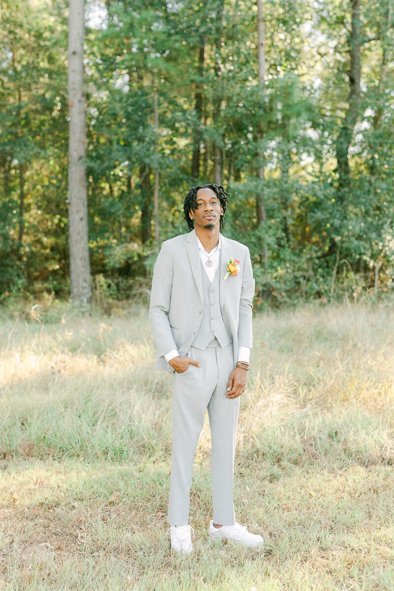 groom in field at magnolia meadows 