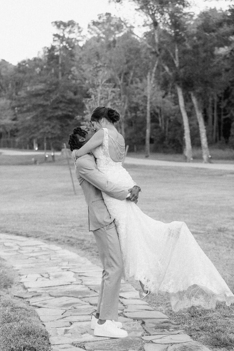 black and white photo of groom spinning bride