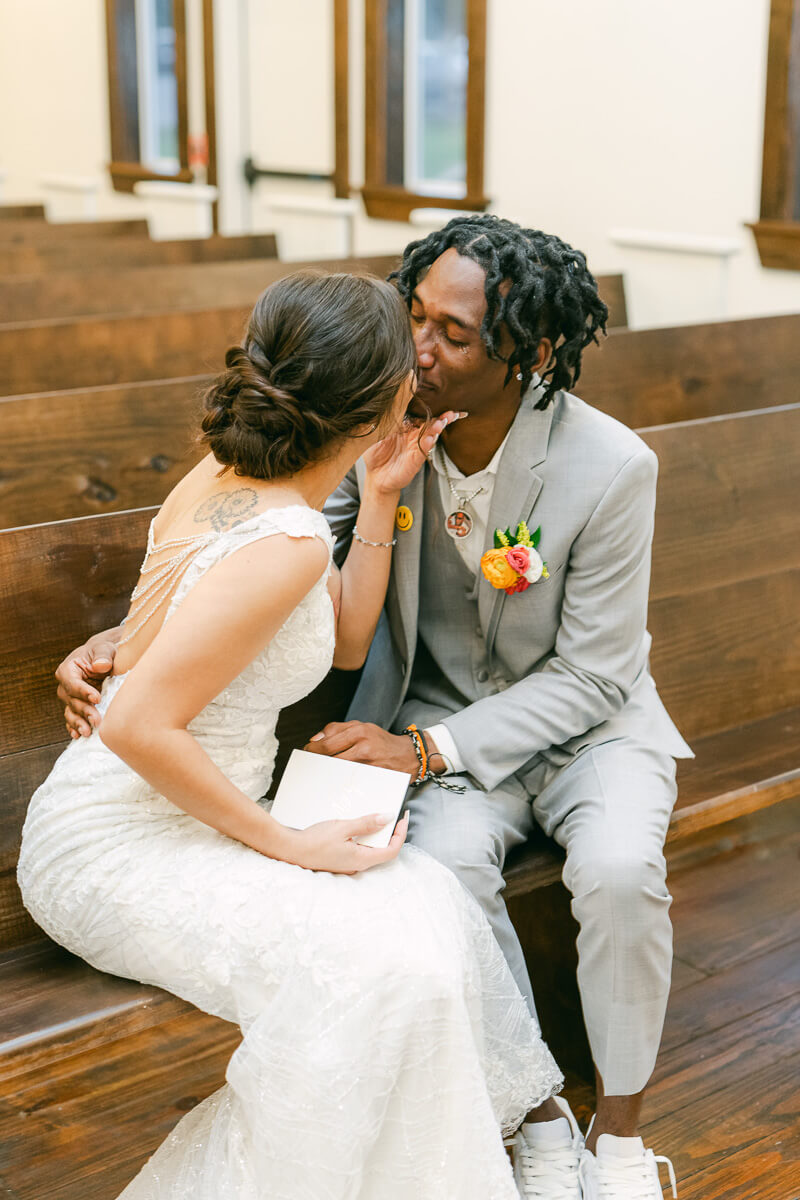 couple kissing after reading vows inside magnolia meadows wedding chapel