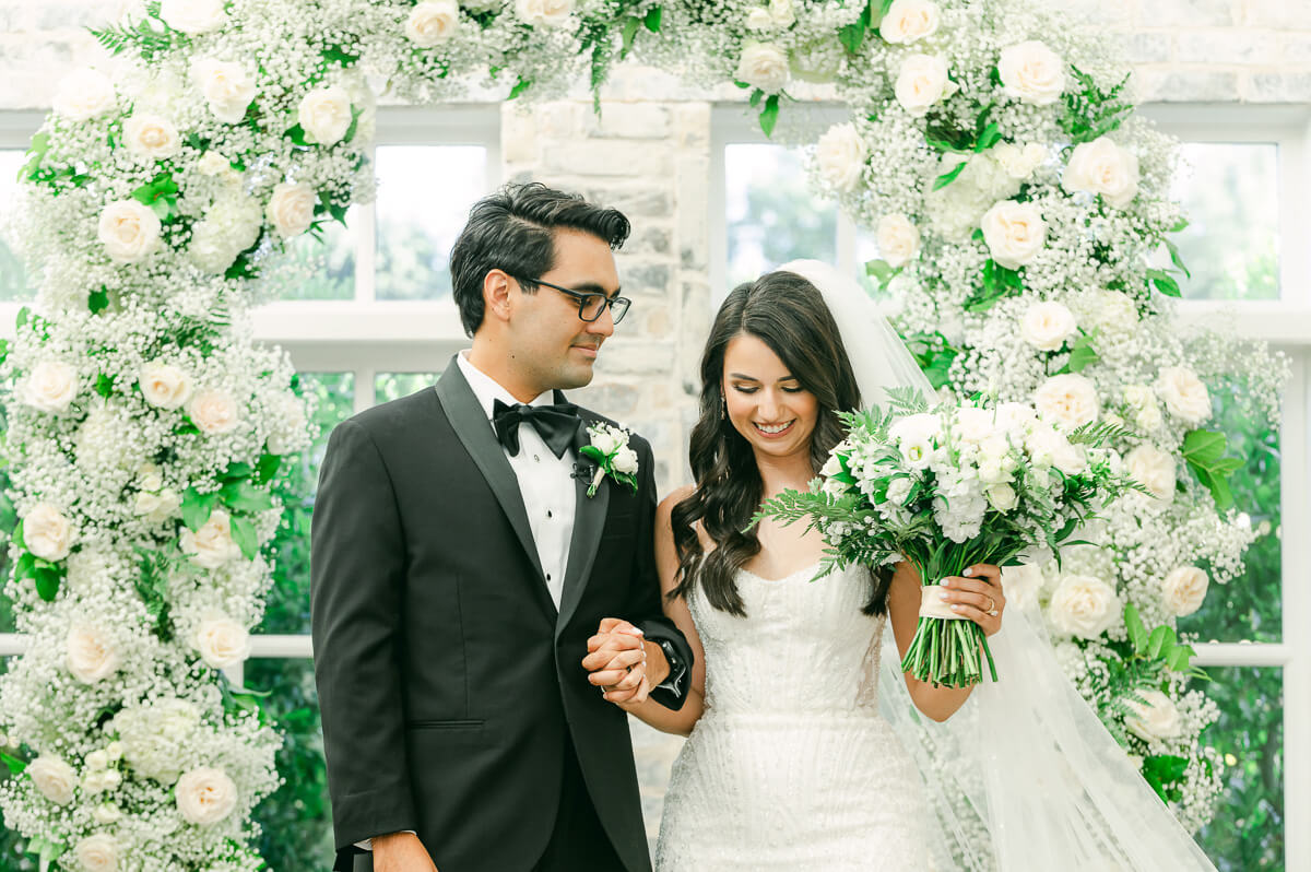 couple in front of flower arch