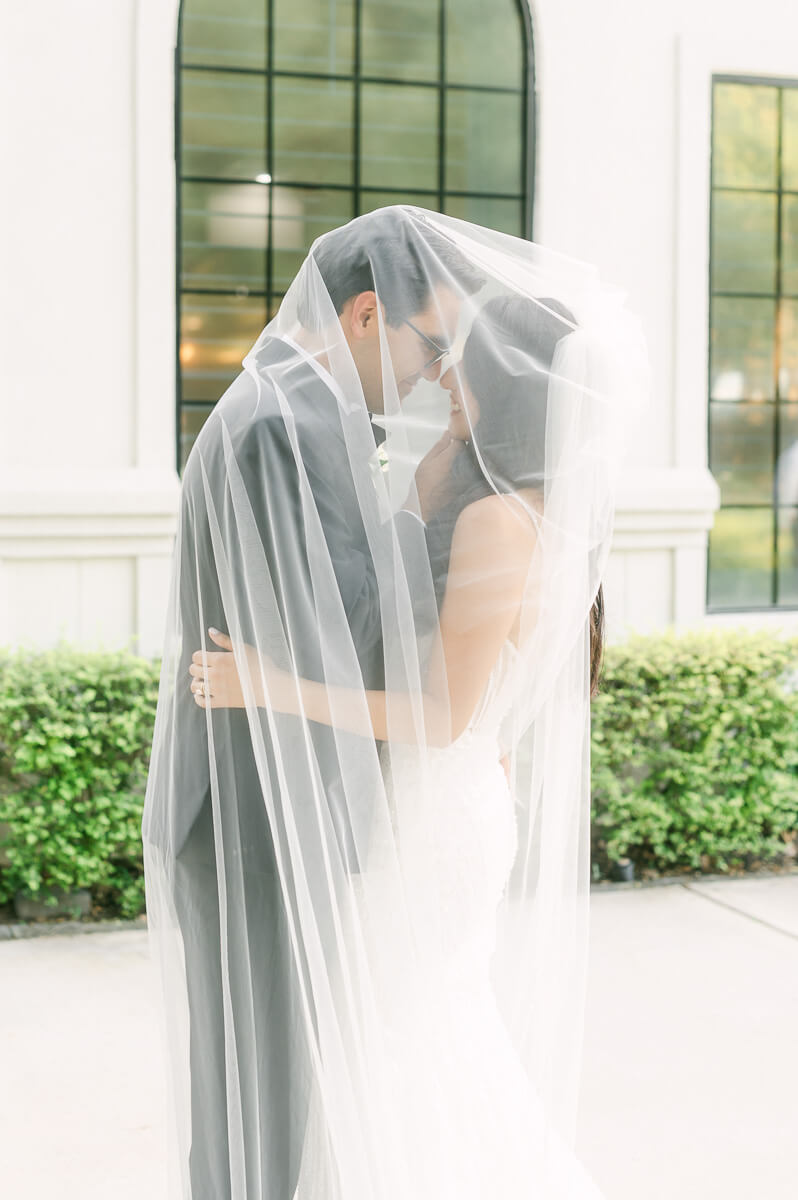 couple under wedding veil by Houston wedding photographer 