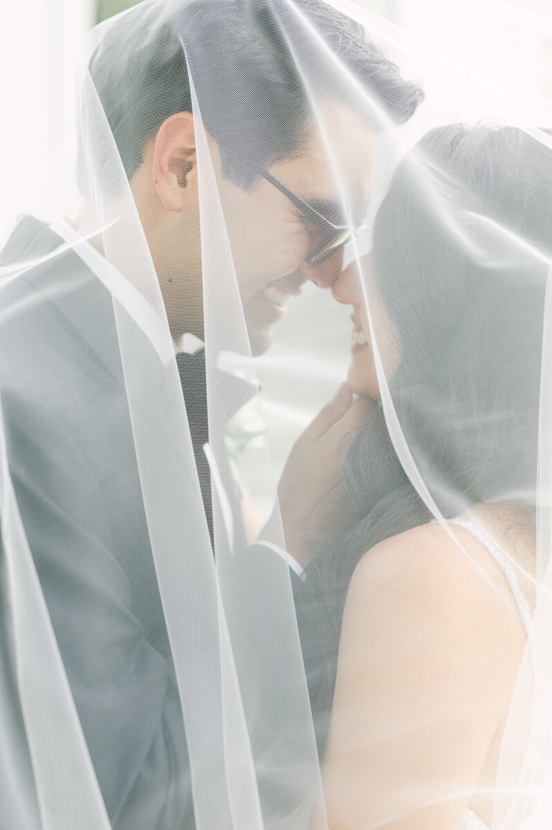 couple under wedding veil by Houston wedding photographer 