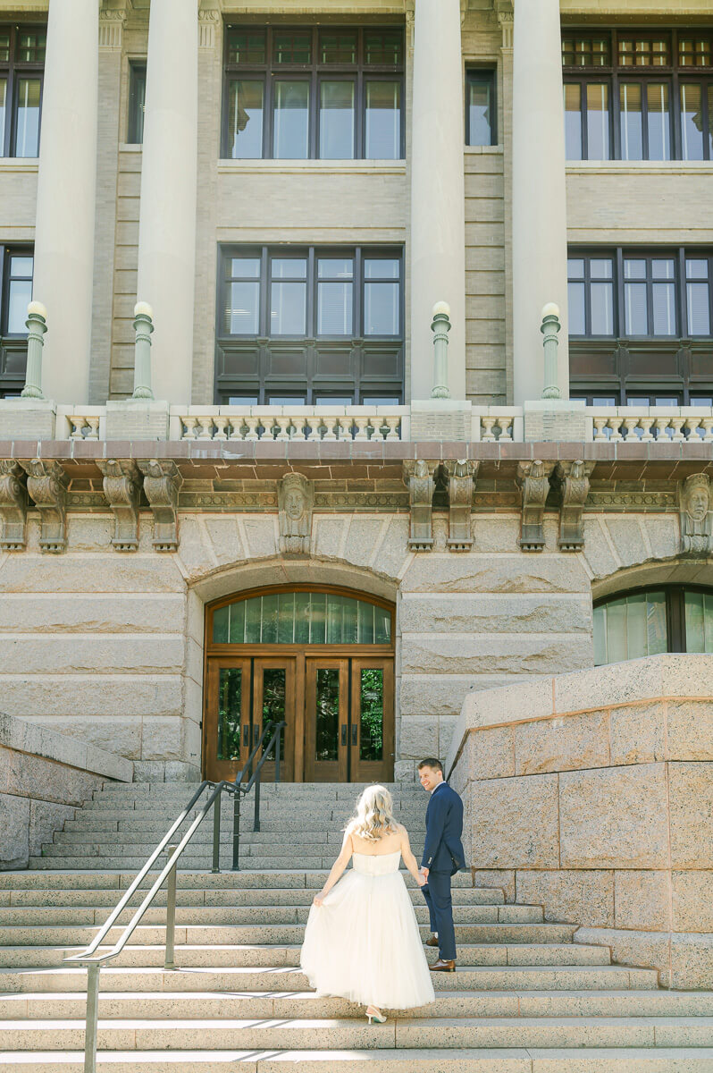 bride and groom posing on steps of downtown Houston historic courthouse