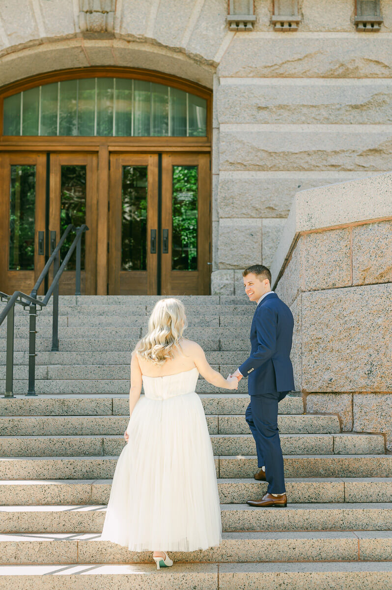 bride and groom posing on steps of downtown Houston historic courthouse