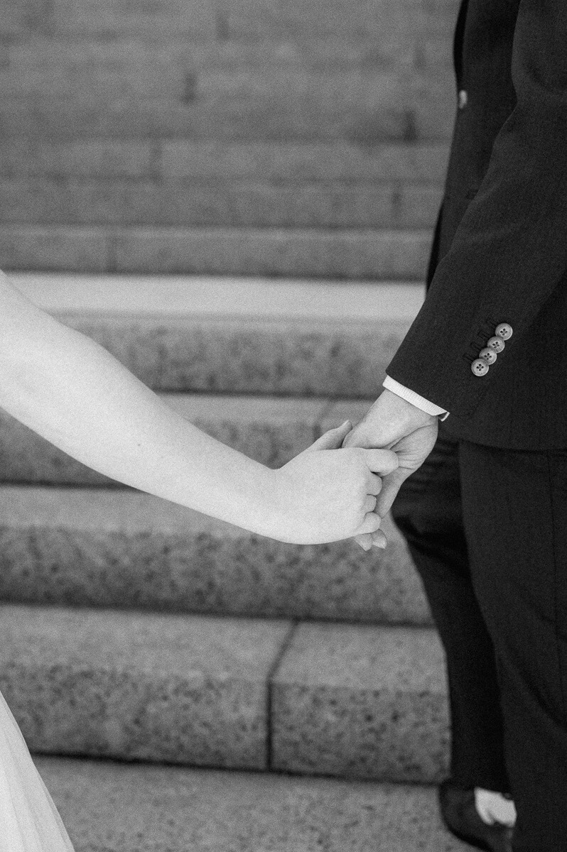 bride and groom posing on steps of downtown Houston historic courthouse