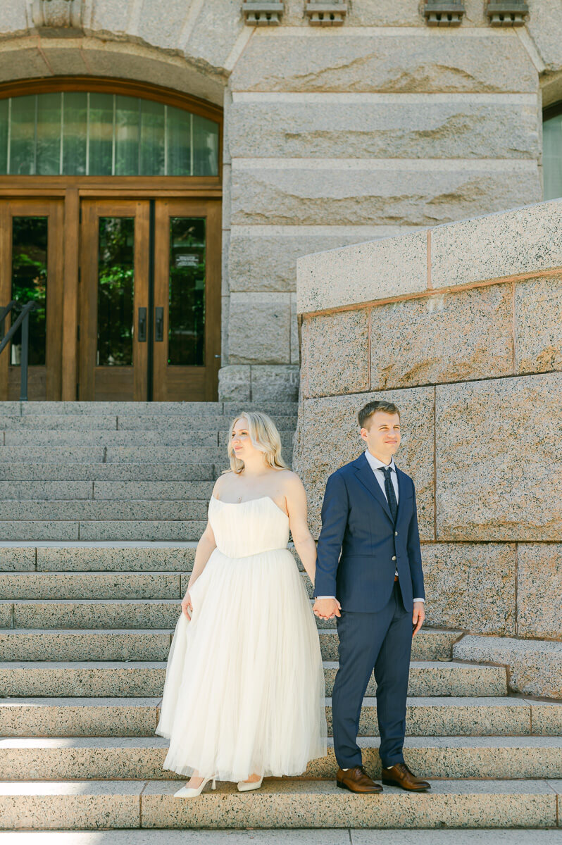 bride and groom posing on steps of downtown Houston historic courthouse