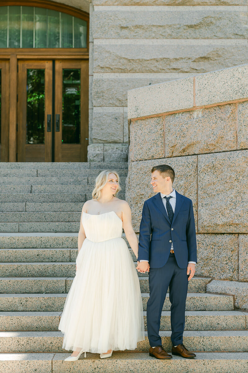 bride and groom posing on steps of downtown Houston historic courthouse