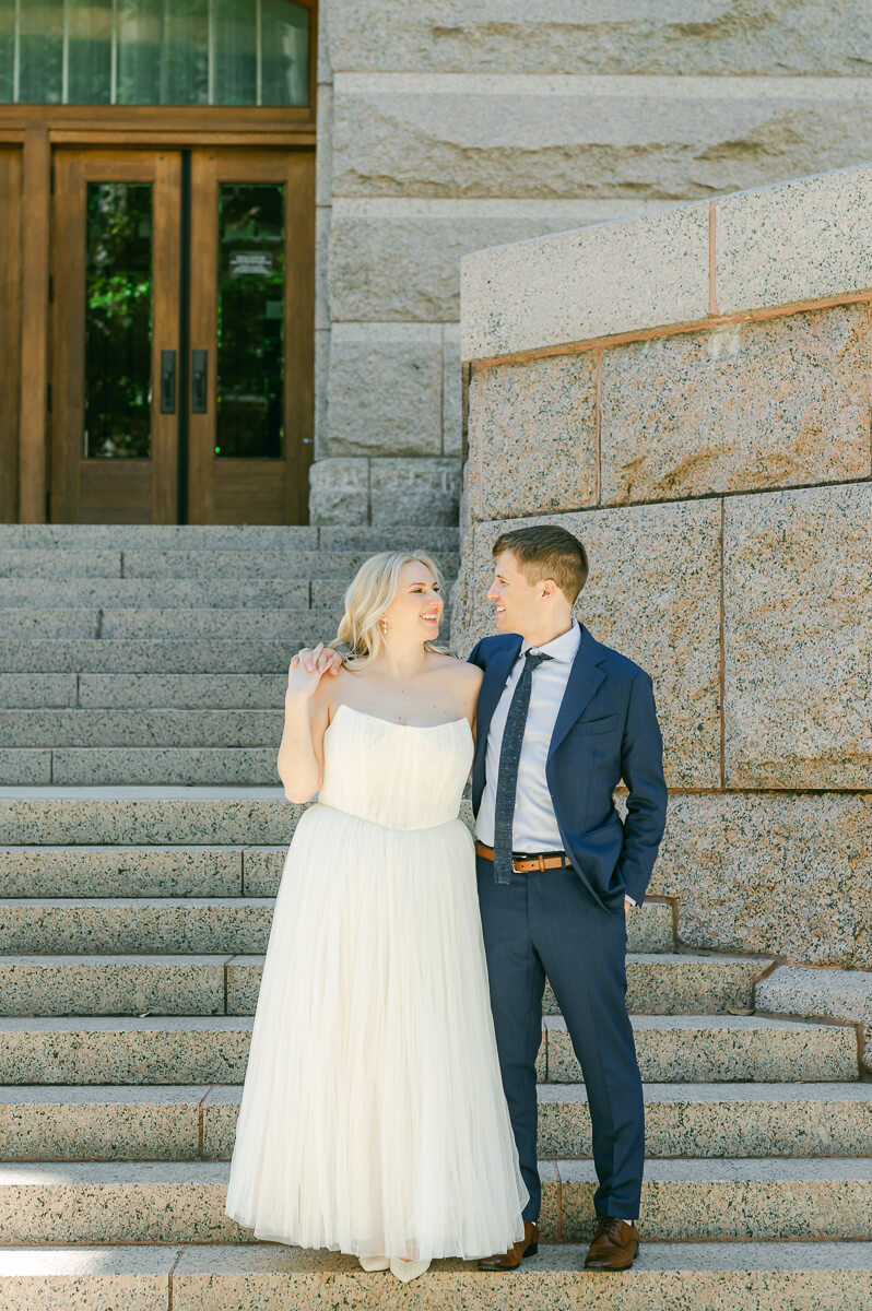 bride and groom posing on steps of downtown Houston historic courthouse