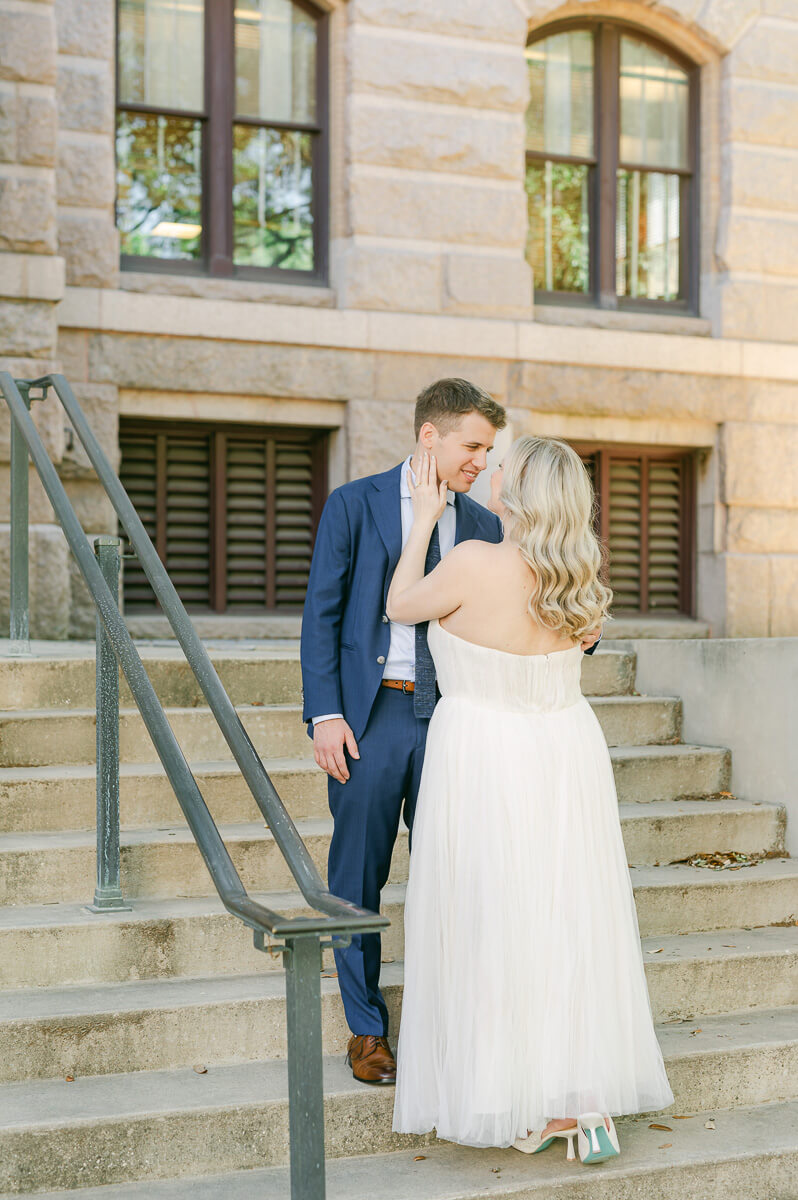 bride and groom posing on steps of downtown Houston historic courthouse