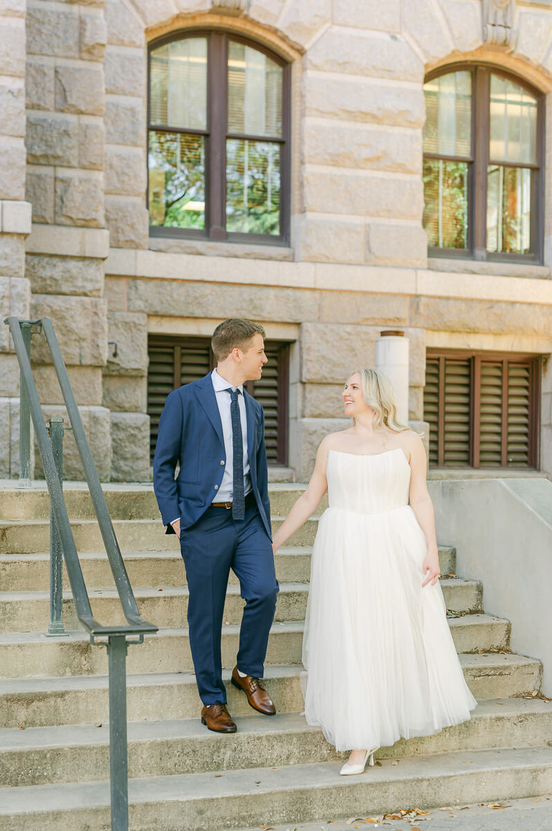 bride and groom posing on steps of downtown Houston historic courthouse
