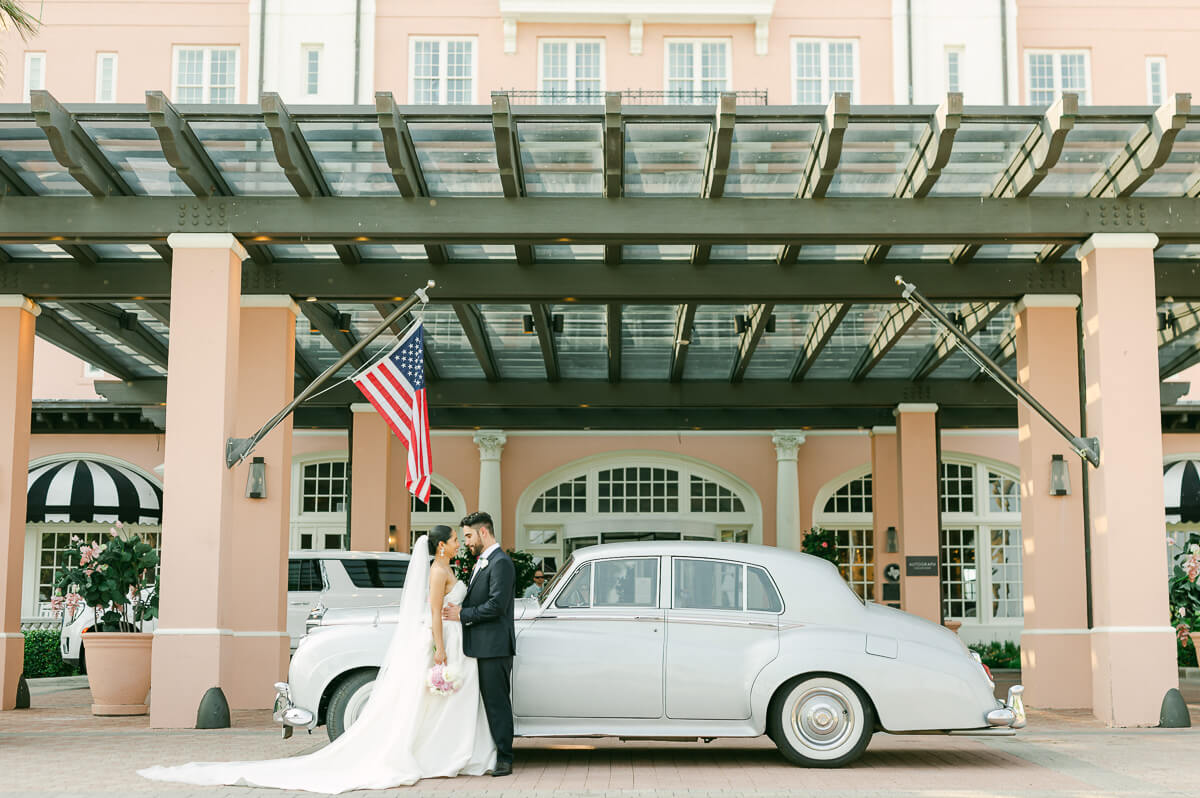 couple at their the grand galvez wedding with vintage car