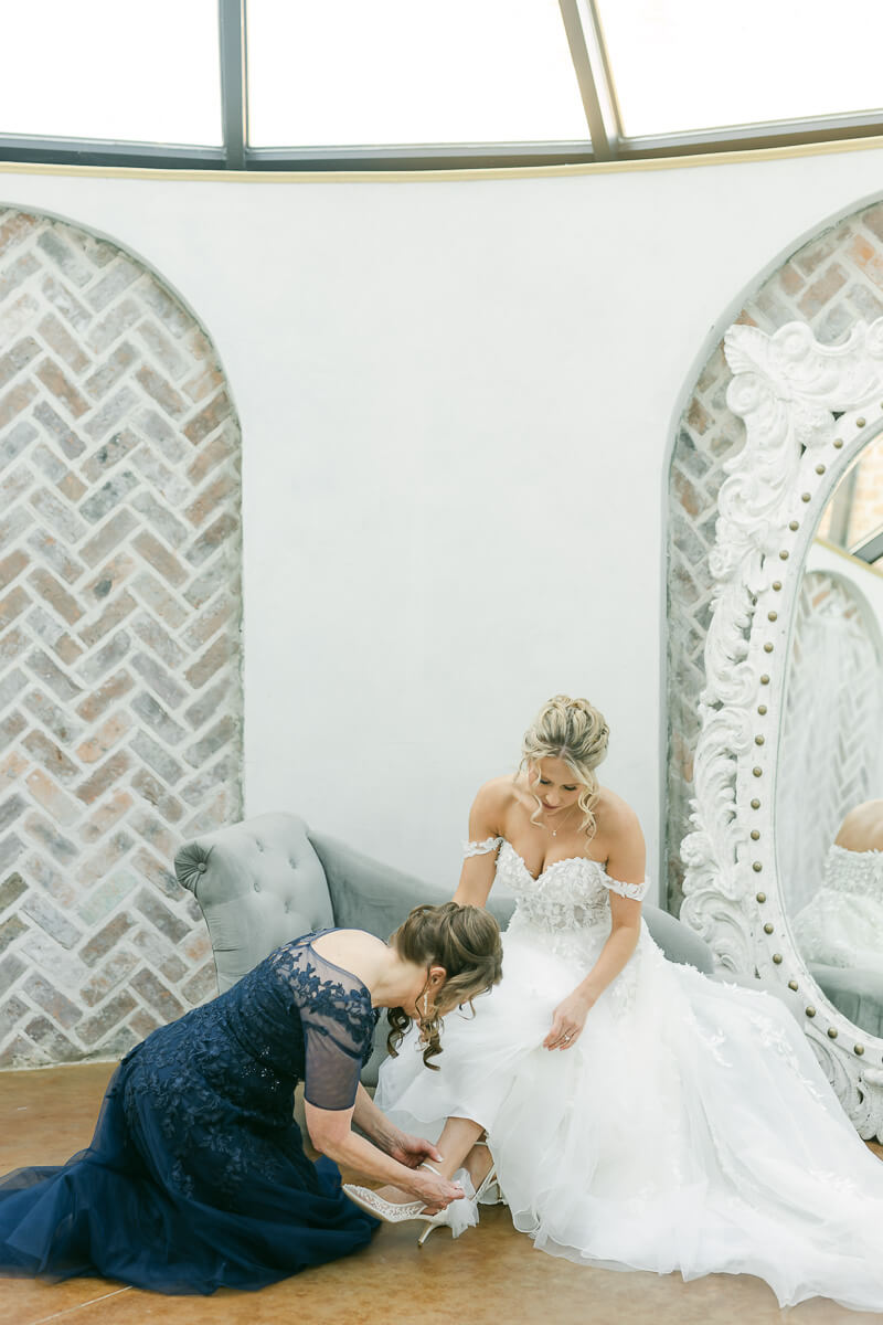 bride putting on her shoes at her wedding in Montgomery, Texas 