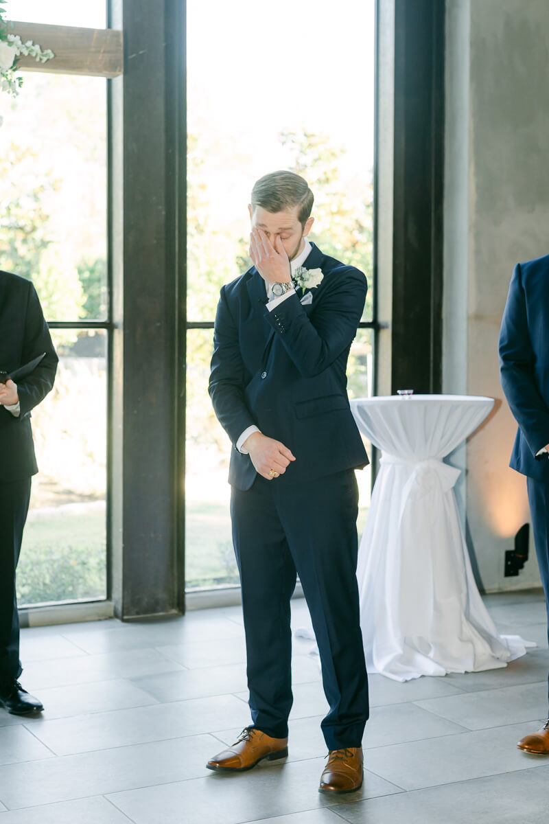 groom crying seeing his bride walk down the aisle