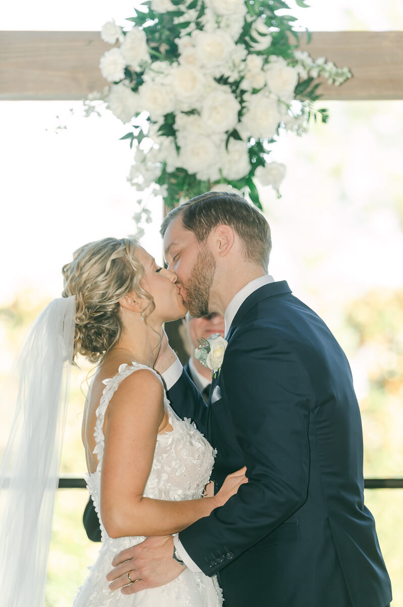 couple kissing during indoor wedding ceremony in Montgomery, Texas