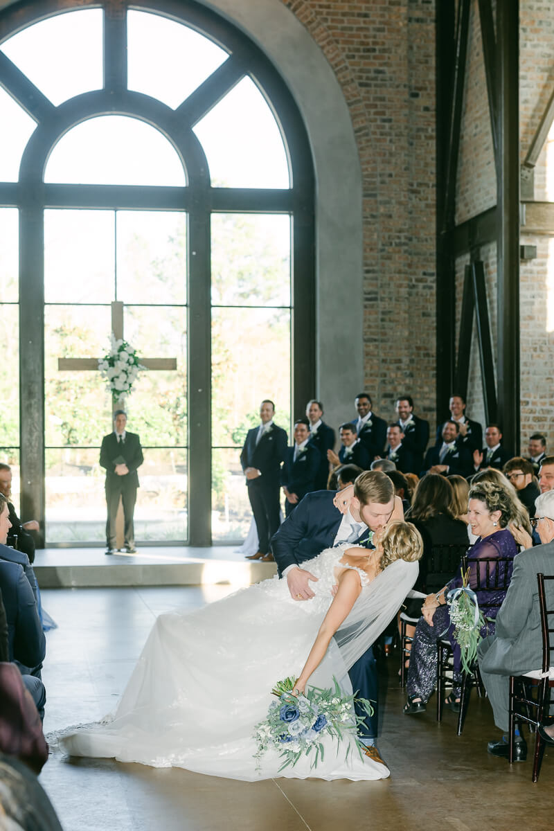 couple kissing during indoor wedding ceremony in Montgomery, Texas