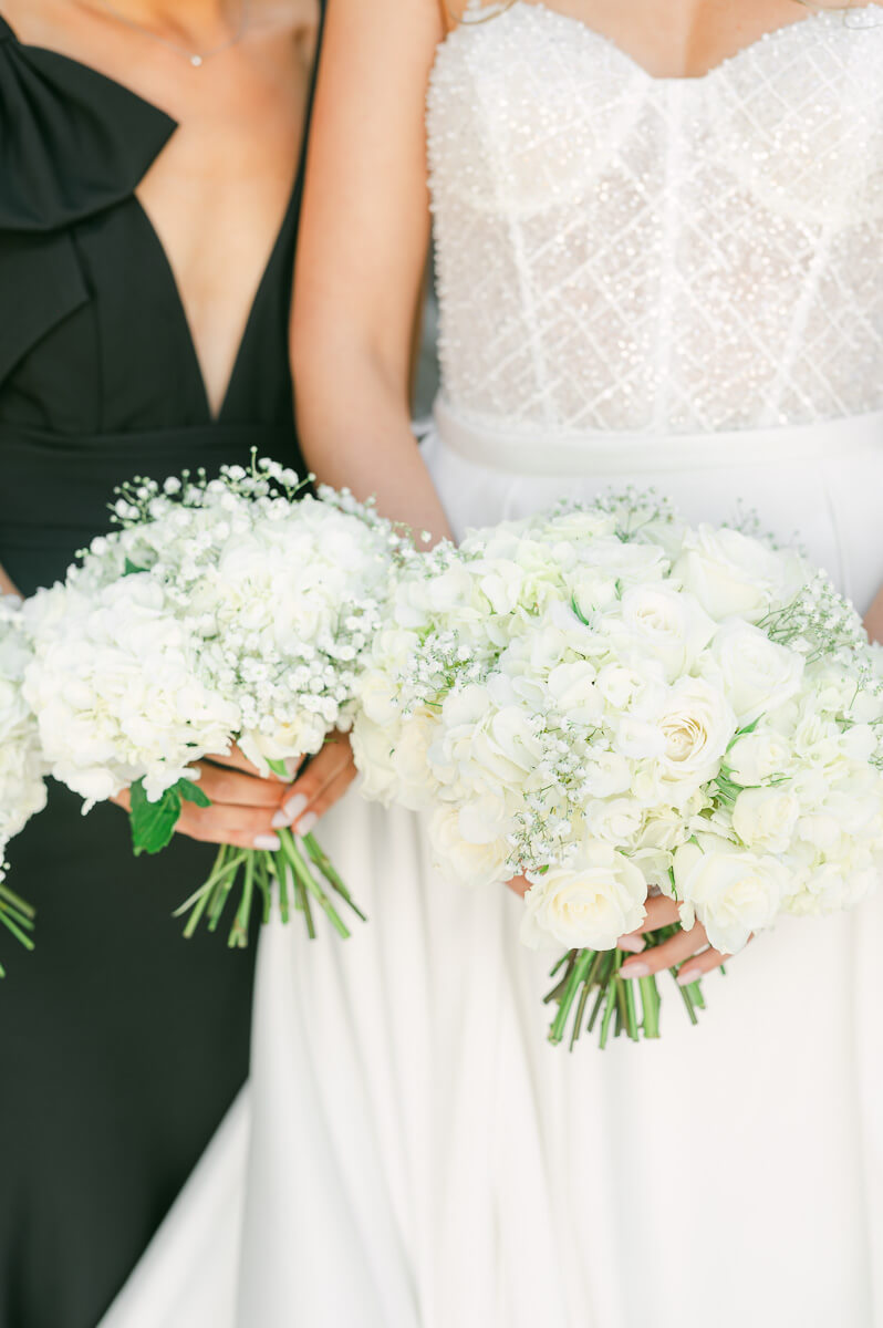 bridesmaids wearing black holding flowers