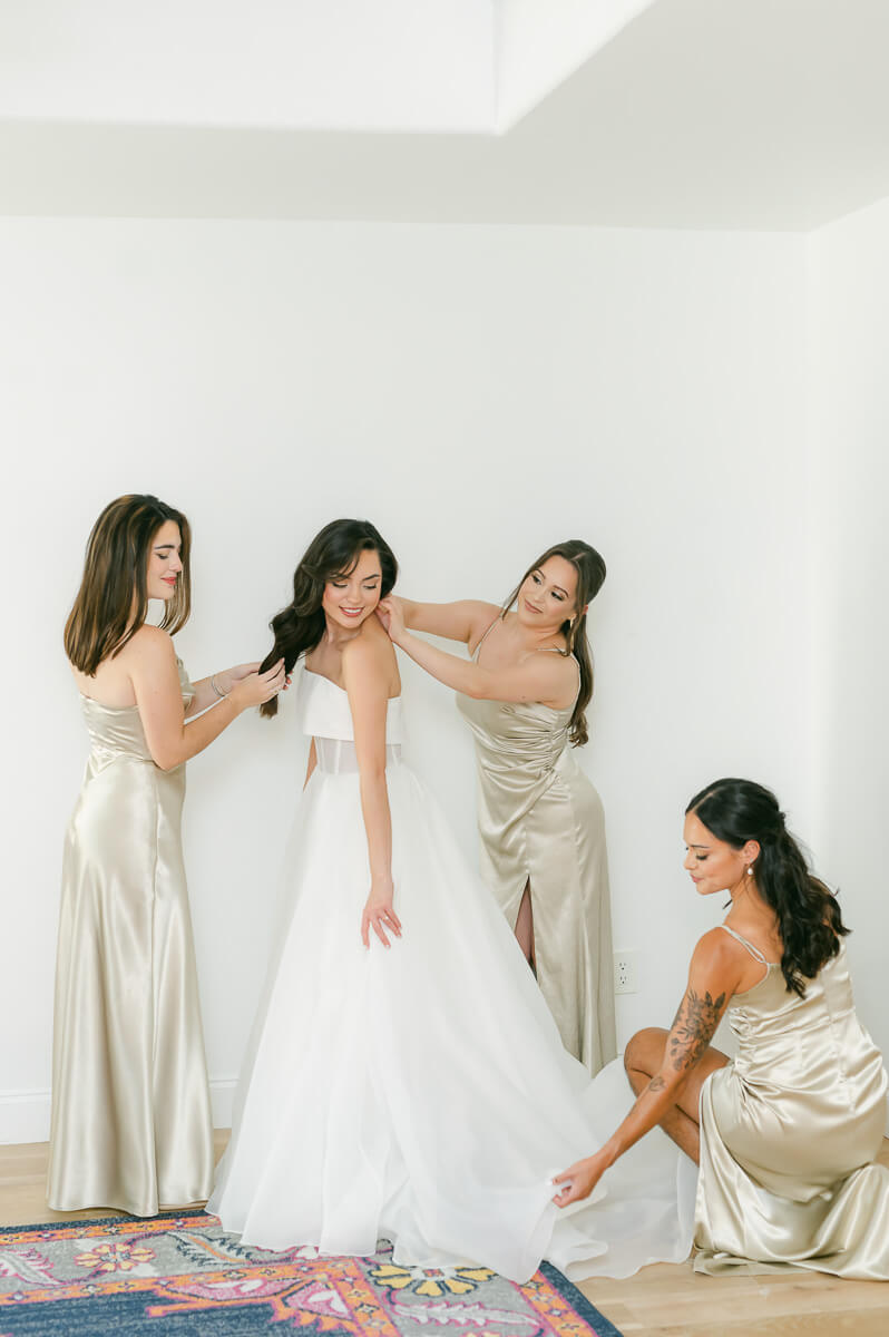 bride getting ready with bridesmaids on wedding day