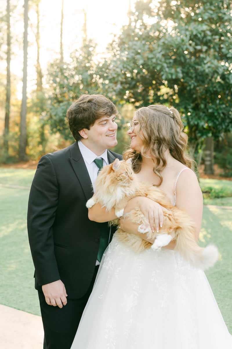 a couple posing with their cat