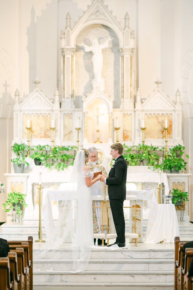 bride and groom during their ceremony at Sacred Heart Catholic Church