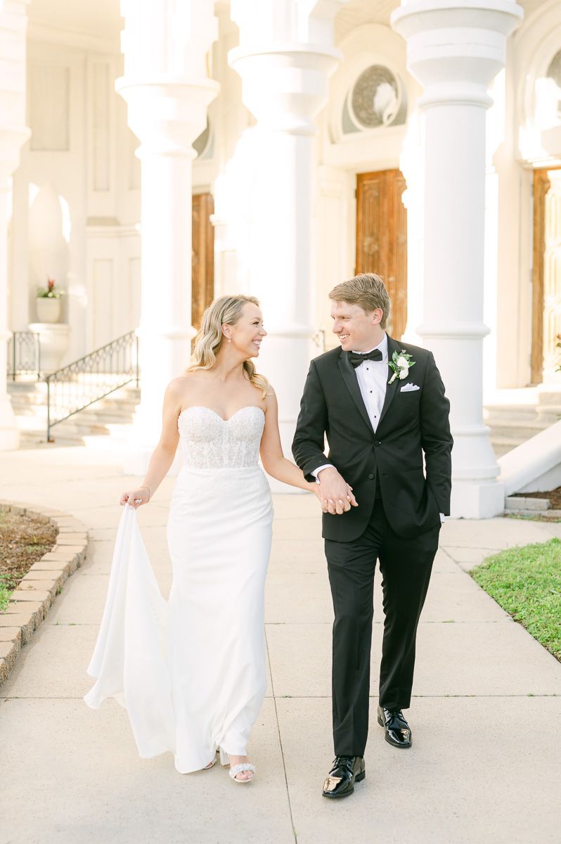 bride and groom walking outside Galveston wedding venue