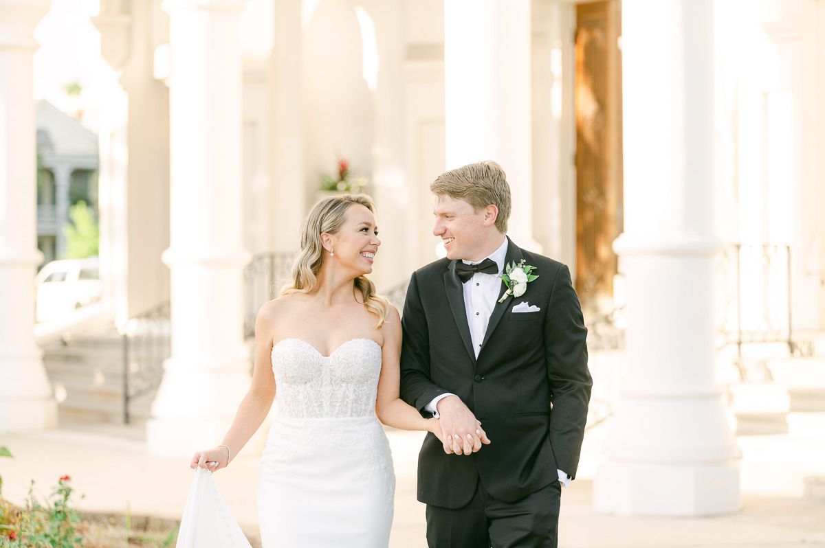 bride and groom walking outside Galveston wedding venue