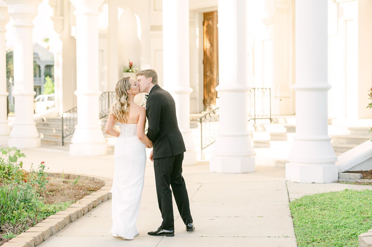 bride and groom kissing outside Galveston wedding venue