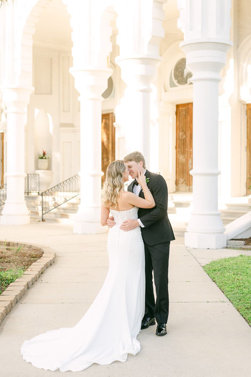 bride and groom cuddling outside Galveston wedding venue