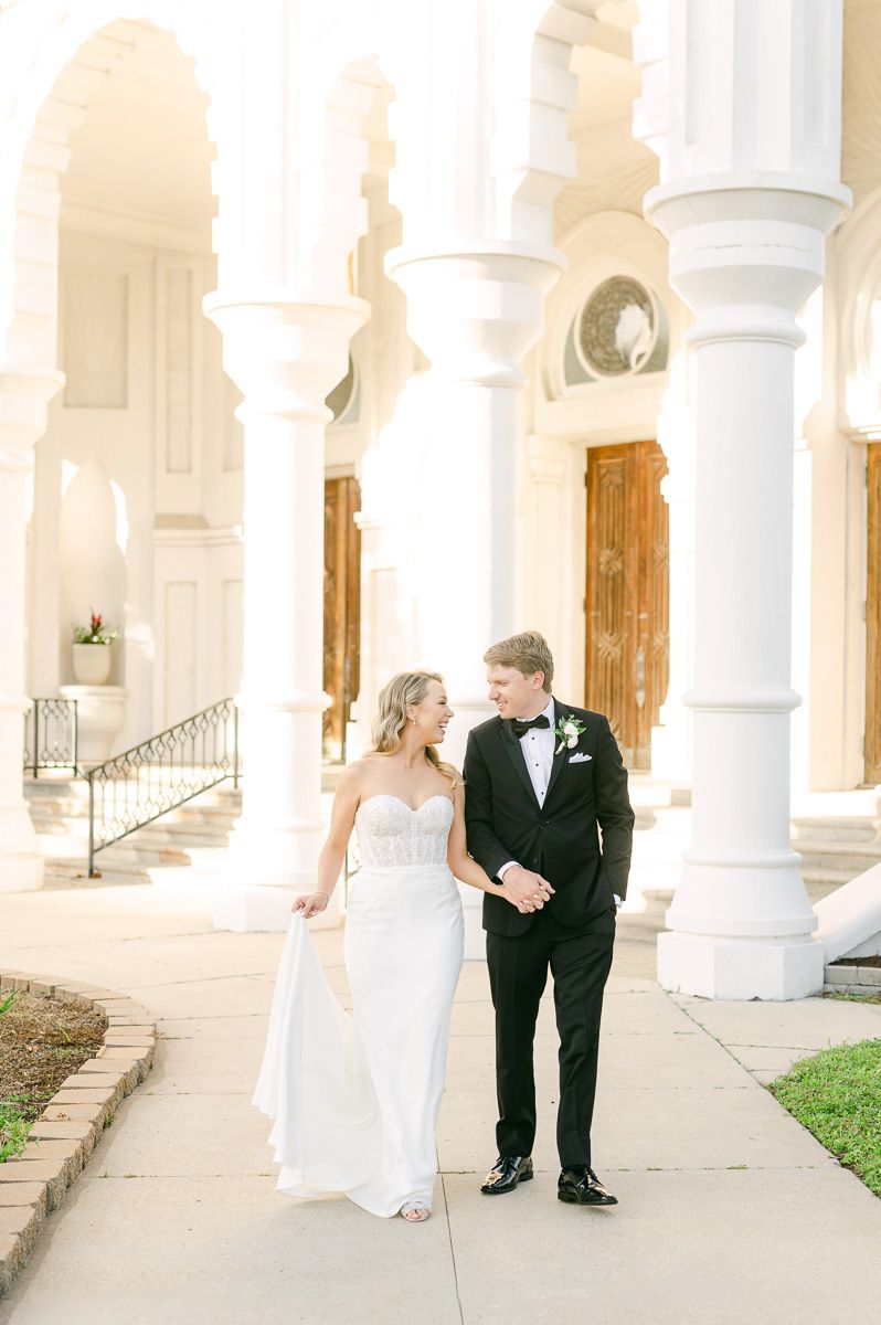 bride and groom walking outside Galveston wedding venue