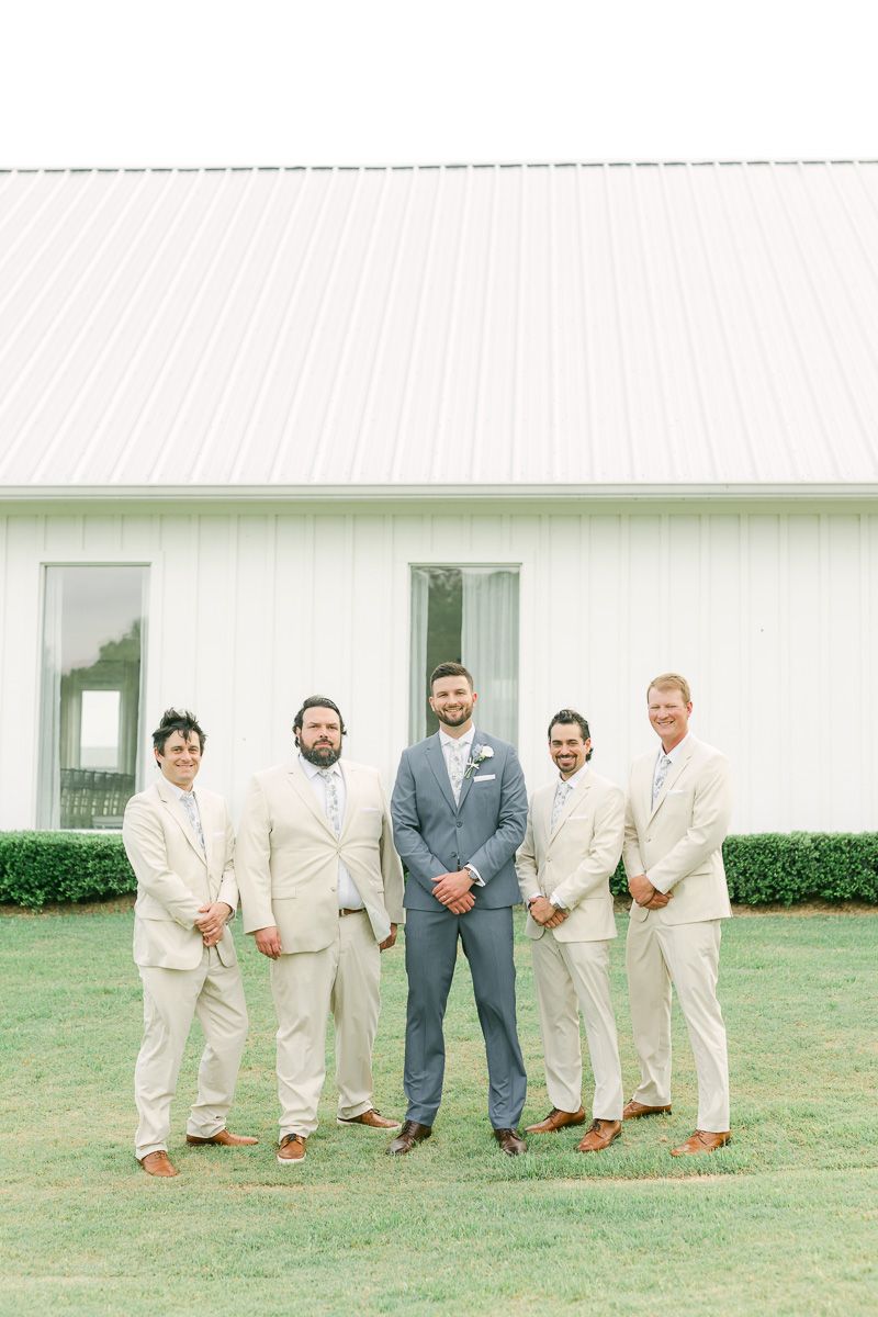 groomsmen in cream suits outside The Farmhouse chapel